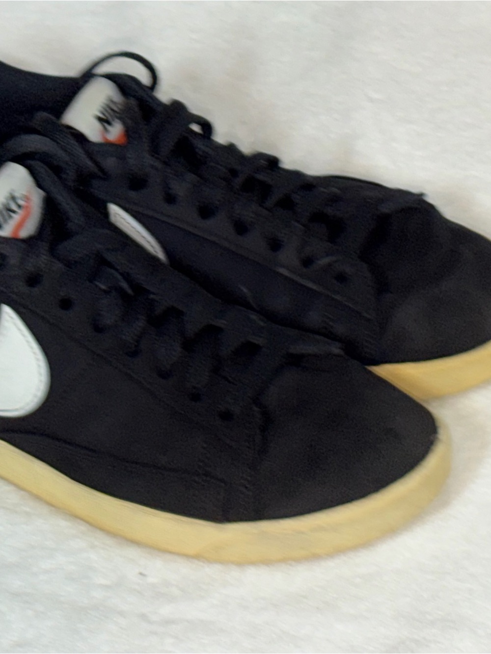 Nike Black Low-Top Sneakers with White Swoosh and Yellowed Sole